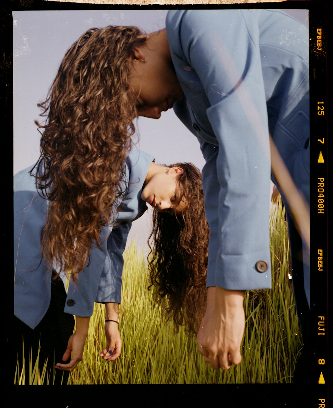 Woman with long curly hair in blue jacket outdoors